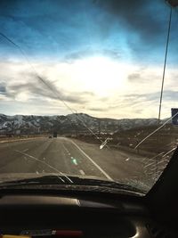 Road against sky seen through car windshield