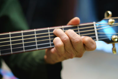 Close-up of man playing guitar