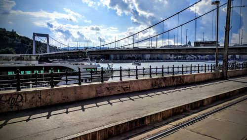 Bridge over river against sky in city