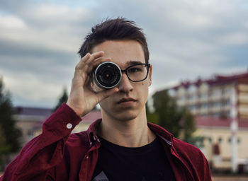 Portrait of mature man wearing sunglasses against sky