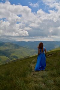 Woman standing on field against sky