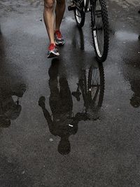 Reflection of people in puddle on road