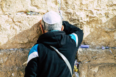 Rear view of man standing against wall