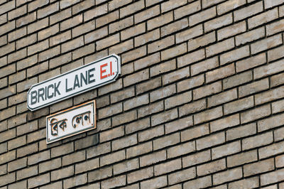 Low angle view of information sign on brick wall