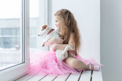 Woman with dog sitting at window