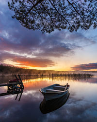 Boat on still lake at sunrise, sweden.