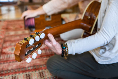 Midsection of woman playing guitar