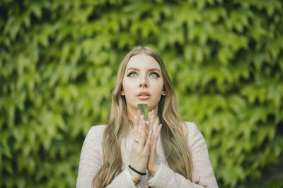 Beautiful young woman holding glass slab outdoors