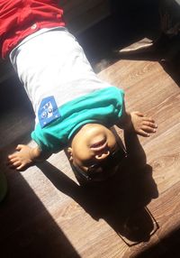 High angle view of young woman lying on hardwood floor