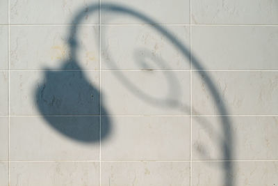 Shadow of lamp on tiled wall