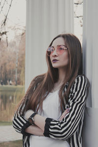 Portrait of young woman wearing eyeglasses standing outdoors