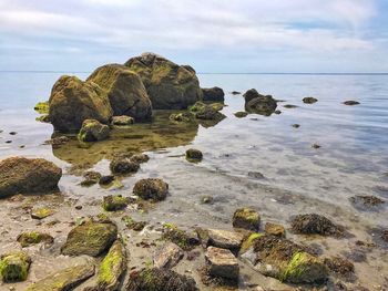 Rocks on sea shore against sky