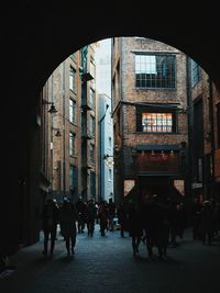 People walking on street amidst buildings in city