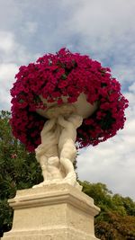 Low angle view of angel statue against cloudy sky