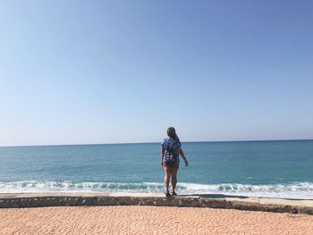 Full length of man on beach against clear sky