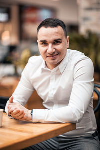 Portrait of man sitting at table in cafe