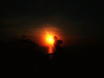 Silhouette men standing against sky during sunset