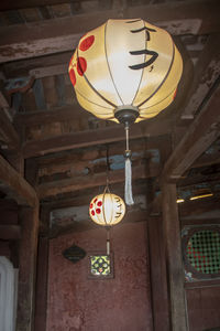 Low angle view of illuminated pendant lights hanging in building