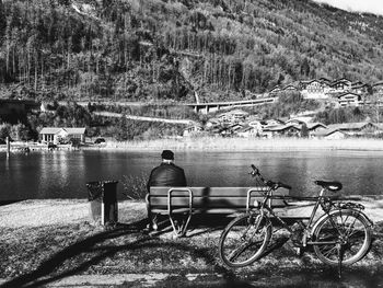 Rear view of man overlooking calm lake