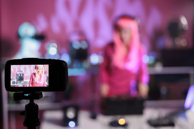 Close-up of woman photographing with smart phone at night