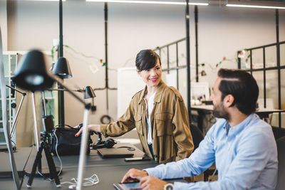 Creative business people talking while working at desk in office