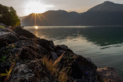 Scenic view of lake against mountains during sunset