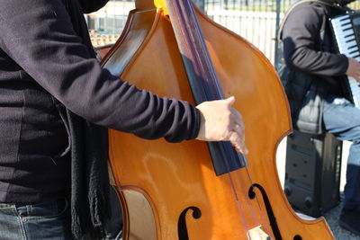 Midsection of man playing guitar