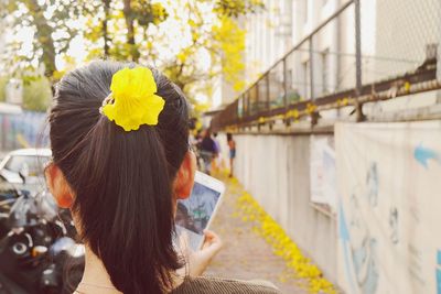 Rear view of woman with flower