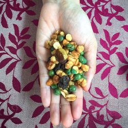 Directly above shot of woman holding roasted nuts at table