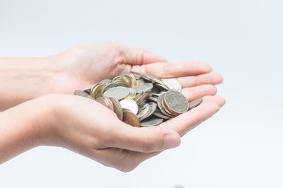 Close-up of hand holding ring over white background