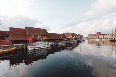 Boats moored in water against sky