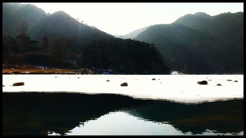 Reflection of trees in lake against clear sky