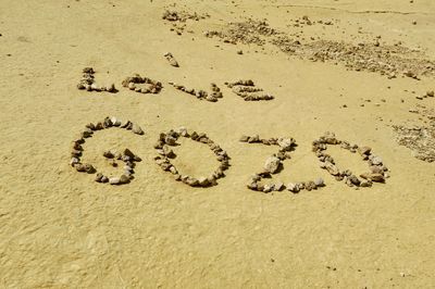 High angle view of text on sand