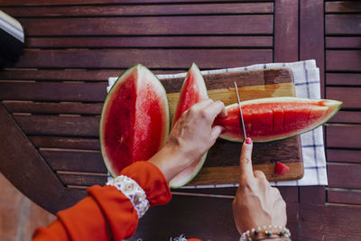 Midsection of man holding red fruit on table