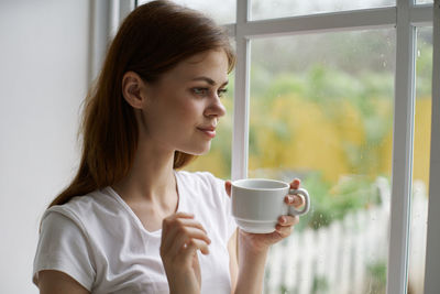 Young woman drinking coffee in cup