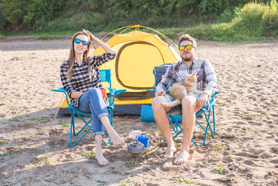 Full length of couple sitting on land