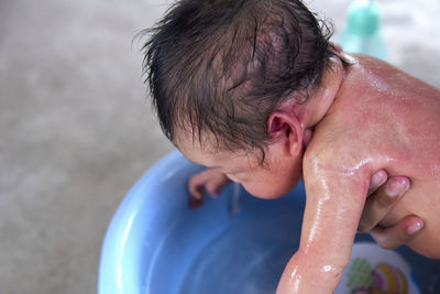 Close-up of shirtless boy washing hands