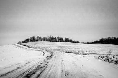 Snow covered landscape against sky