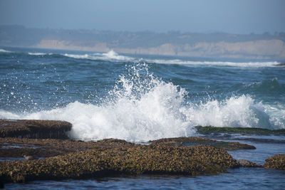 Waves splashing on rocks in sea