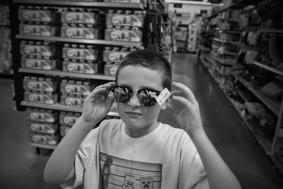 Portrait of boy wearing sunglasses while standing in store