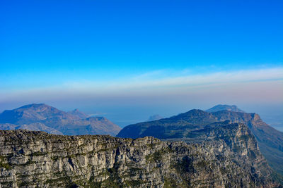 Scenic view of mountains against blue sky