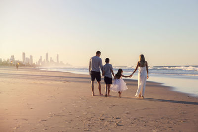 Rear view of people walking on beach