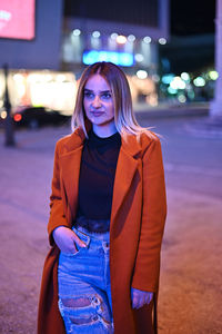 Portrait of beautiful woman in illuminated city at night