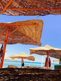 Gazebo by sea against clear blue sky