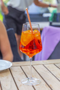 Sommer aperitif drink with alcohol and ice and straw on outdoor table