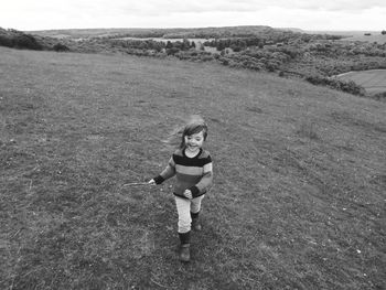 High angle view of girl running on grassy field against sky