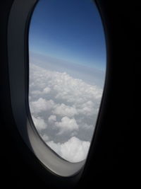 View of cloudy sky seen through airplane window