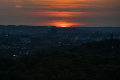 Silhouette buildings against sky at sunset