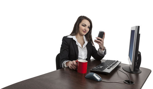 Young woman using mobile phone on table