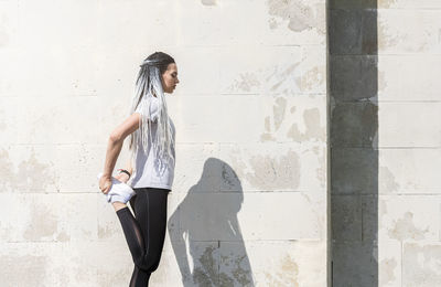 Woman standing against white wall